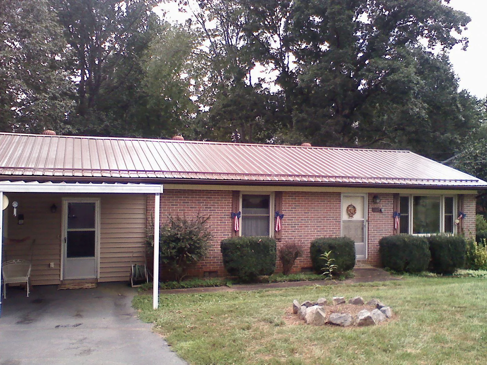 Bronze metal roof and carport on a brick ranch home — Roof Repair work by our crew in Palm Harbor